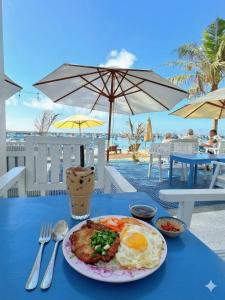 a plate of breakfast food on a blue table with an beach at Babylon Hotel Phu Quy in Cu Lao Thu