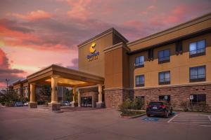a hotel with a car parked in a parking lot at Comfort Suites Old Town Spring in Spring