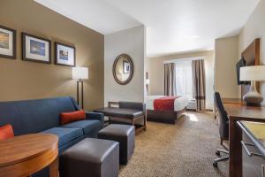 a hotel room with a couch and a bed at Comfort Suites Old Town Spring in Spring