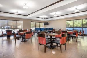 a dining room with tables and chairs and windows at Comfort Suites Old Town Spring in Spring