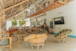 a living room with chairs and a table and a couch at Sunset Mkuu Boutique Hotel in Michamvi