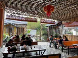 a group of people sitting at tables in a restaurant at Flora Garden Homestay in Xuân Sơn