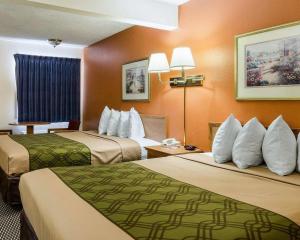 two beds in a hotel room with orange walls at Econo Lodge Lawrence near University in Lawrence +23 photos