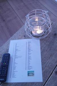 un morceau de papier et une télécommande sur une table dans l'établissement SteR Appartement Zandvoort, à Zandvoort