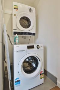 a washing machine and a dryer in a room at Quality Apartments Dandenong in Dandenong