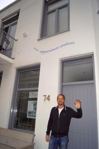 ザントフォールトにあるSteR Appartement Zandvoortの建物前に立つ男