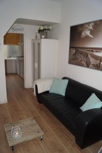 - un salon avec un canapé noir et une table dans l'établissement SteR Appartement Zandvoort, à Zandvoort