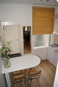 a small kitchen with a white counter top and a table at SteR Appartement Zandvoort in Zandvoort