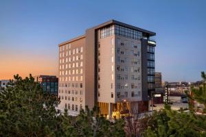 a tall building with a sunset in the background at Cambria Hotel Nashville Midtown in Nashville