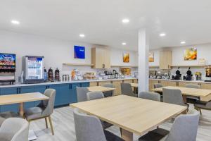 a cafeteria with tables and chairs and a kitchen at Comfort Inn Sea World Area in San Diego