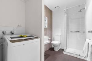 a white bathroom with a toilet and a shower at Comfort Apartments on Elizabeth in Melbourne +72 photos