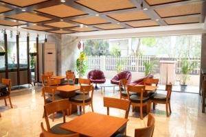 a restaurant with wooden tables and chairs and a large window at Magnus Lxia Premier, Kalyani Nagar Pune in Pune