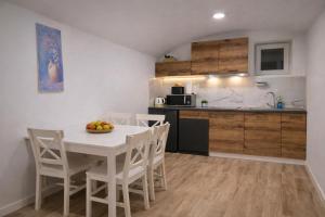 a kitchen and dining room with a white table and chairs at DINLUX Apartment in Maribor +12 photos