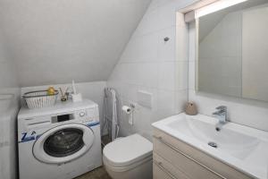 a bathroom with a washing machine and a sink at DINLUX Apartment in Maribor