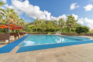 a swimming pool in a resort with palm trees at Dammora Resort in Seogwipo