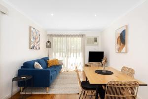 a living room with a blue couch and a table at Charming CBD cottage - walk everywhere in Mount Gambier