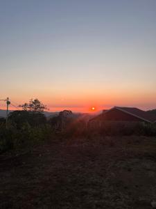 a sunset over a field with the sun in the sky at Manjosila Homestay in Mirik