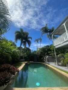 a swimming pool in front of a house with palm trees at Somerset Palms Studio Apartment in Horseshoe Bay