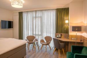 a hotel room with a bed and a desk and chairs at Hotel Erve Hulsbeek in Oldenzaal