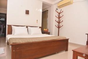 a bedroom with a wooden bed with white pillows at The Lark Resort ,induruwa in Induruwa