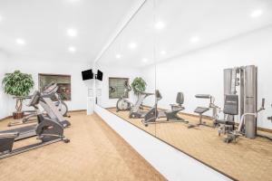 a gym with treadmills and elliptical machines at Baymont by Wyndham Pearsall in Pearsall