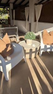 two white chairs and a table on a patio at Casa Jeyel in Lazise