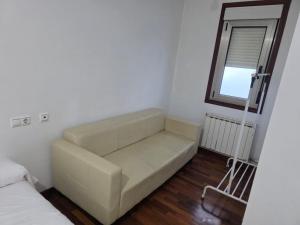 a living room with a couch and a window at Smart English Rooms in O Mesón Do Vento 