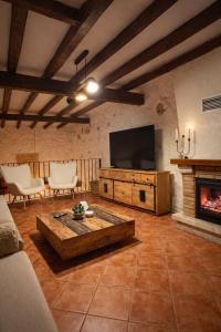 a living room with a tv and a fireplace at Casa Rural La Font in Sant Mateu