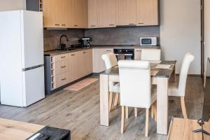 a kitchen with a table and a white refrigerator at Tryavna Central Apartments-Relax in Tryavna