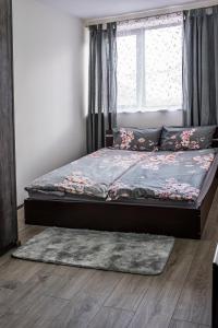 a bed in a bedroom with a window and a rug at Tryavna Central Apartments-Relax in Tryavna