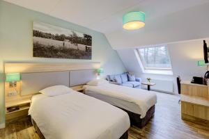 a hotel room with two beds and a chair at Hotel Erve Hulsbeek in Oldenzaal +49 photos