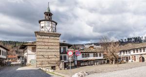 a building with a clock tower on a street at Tryavna Central Apartments-Relax in Tryavna