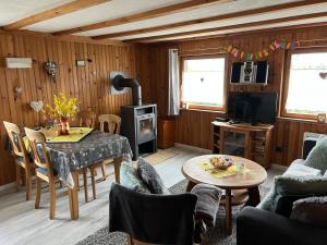 a living room with a table and a stove at Gîte le Nid in Langatte