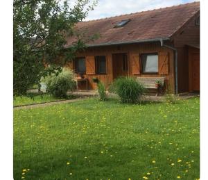 a house with a yard with grass and flowers at Gîte le Nid in Langatte