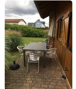 a table and chairs on a brick patio at Gîte le Nid in Langatte +15 photos