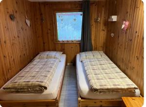 two beds in a room with a window at Gîte le Nid in Langatte