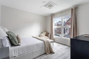 a white bedroom with a bed and a window at Stylish Yale Wooster Square Downtown Laundry in New Haven