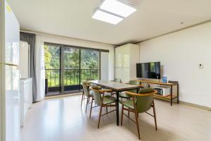 a kitchen and dining room with a table and chairs at Dammora Resort in Seogwipo