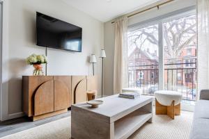 a living room with a large window and a tv at Stylish Yale Wooster Square Downtown Laundry in New Haven