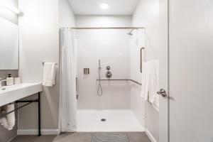 a white bathroom with a shower and a sink at Stylish Yale Wooster Square Downtown Laundry in New Haven +44 photos