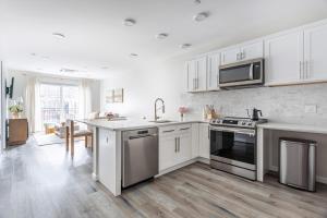 a kitchen with white cabinets and stainless steel appliances at Stylish Yale Wooster Square Downtown Laundry in New Haven