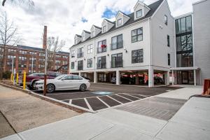 a white car parked in a parking lot in front of a building at Stylish Yale Wooster Square Downtown Laundry in New Haven