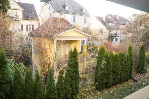 una casa gialla con un mucchio di alberi in un cortile di Appartement Langhammer a Tubinga