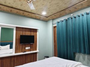 a bedroom with a bed and a flat screen tv at Hotel Ajmer Pride in Ajmer +26 photos