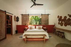 a bedroom with a bed and a ceiling fan at Lasai Villas in Gili Islands