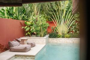 a swimming pool in a garden with plants at Lasai Villas in Gili Islands