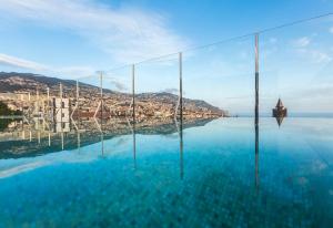 a swimming pool with a view of the water at Castanheiro Boutique Hotel in Funchal