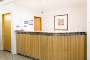 eine Lobby mit einer Holztheke und zwei Türen in der Unterkunft Days Inn by Wyndham Kimball in Kimball
