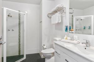 a white bathroom with a shower and a toilet at Quality Hotel Dickson in Canberra