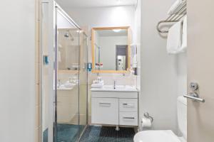a bathroom with a shower and a sink and a toilet at Quality Hotel Dickson in Canberra